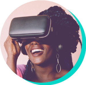 A smiling Black woman with braided hair wearing a VR headset, with a look of joyful surprise on her face. The background is a soft pink.